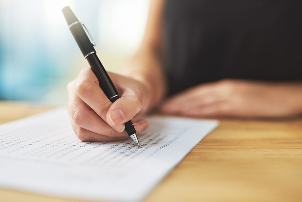 Assessment time. Shot of a woman filling in an answer sheet for a test.