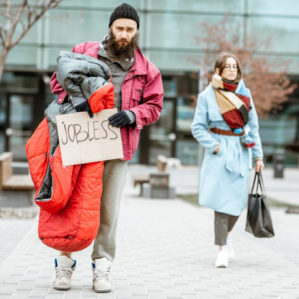 Homeless beggar with passing by business woman
